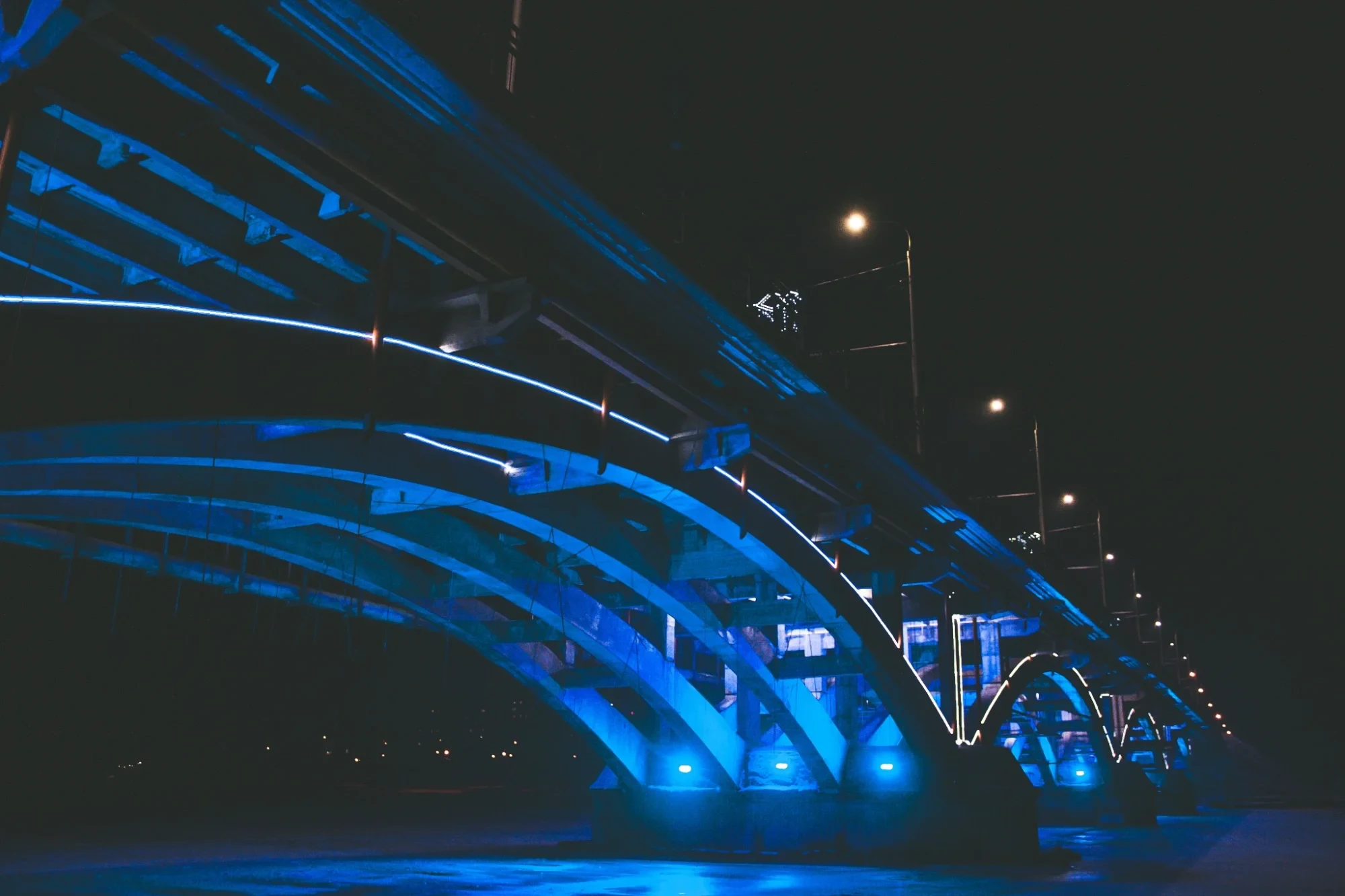 A bridge illuminated in blue at night